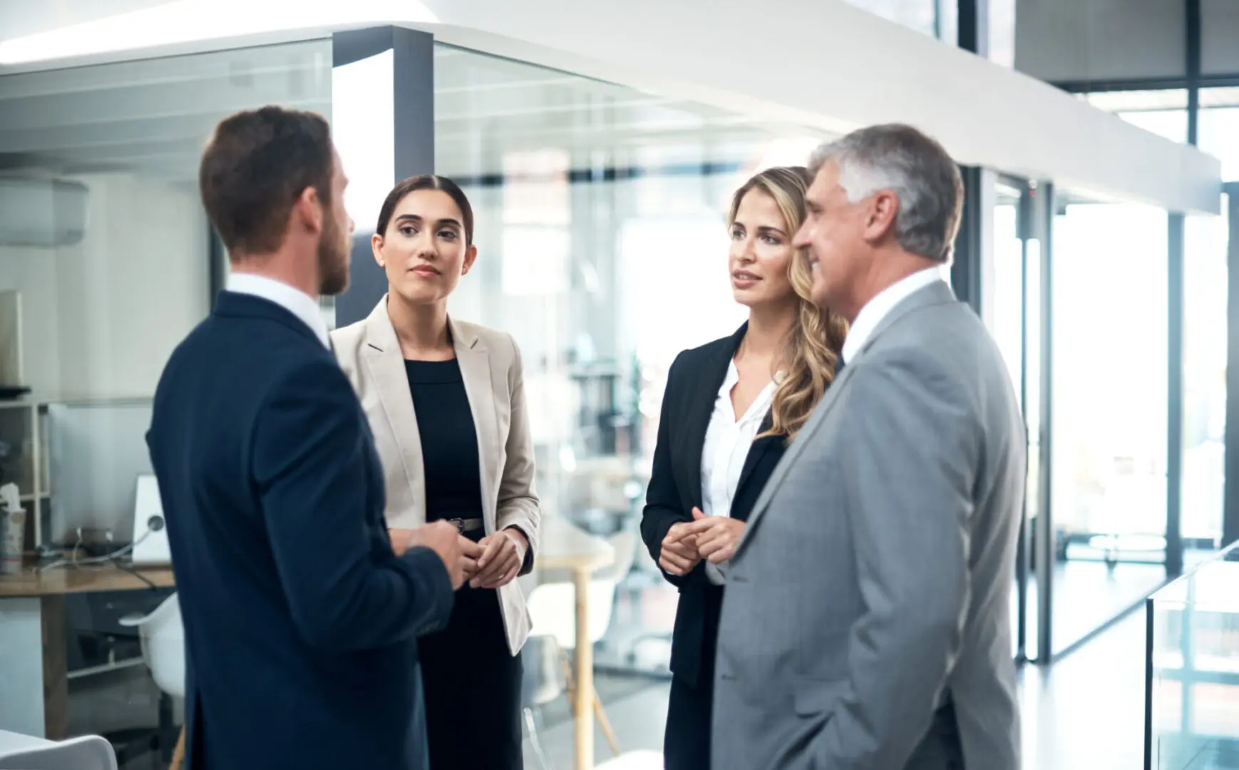 A group of people standing around talking to each other.